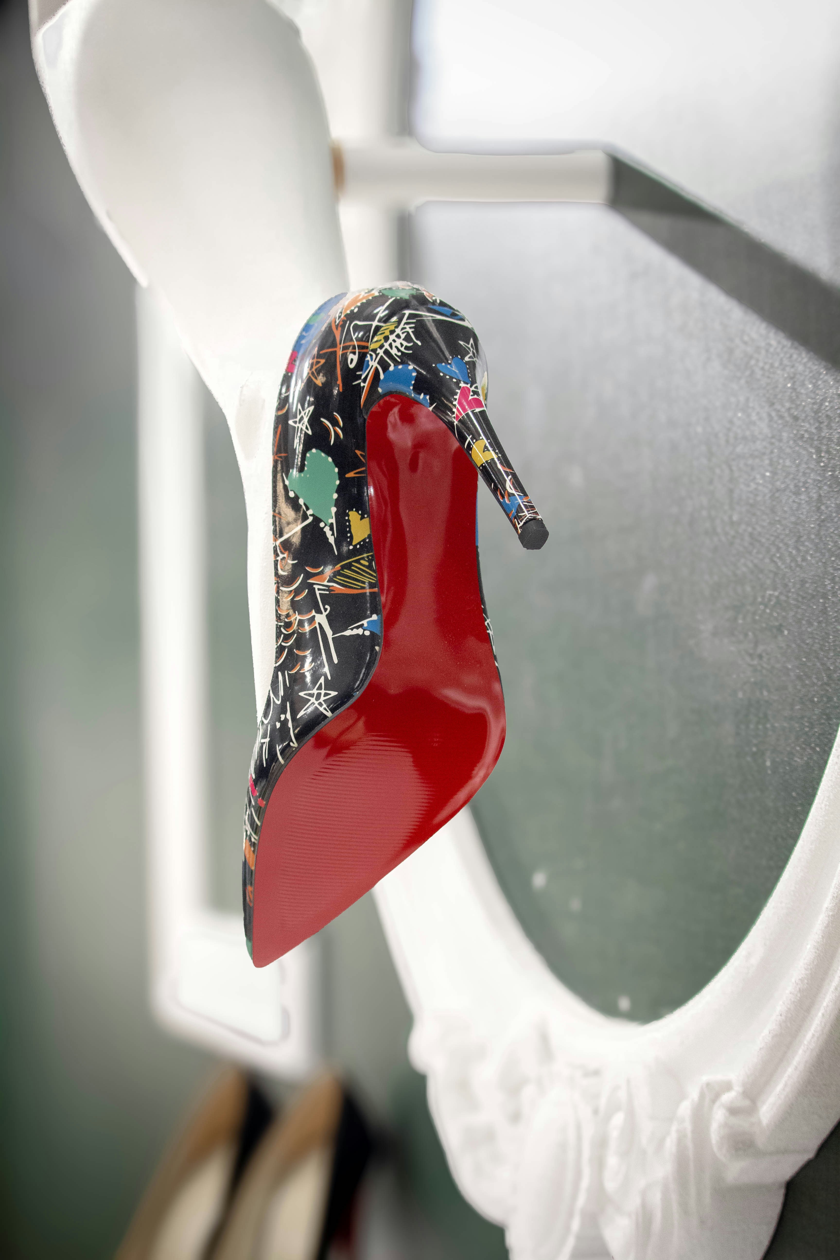 a red shoe hanging from a hook in a bathroom
