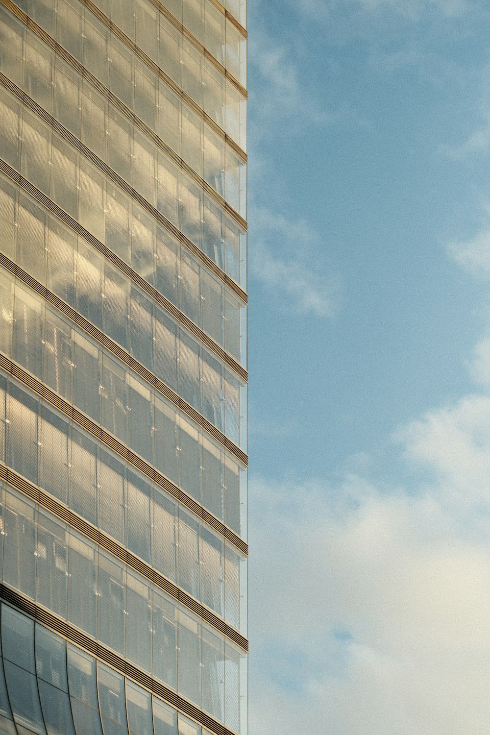 a plane flying in the sky near a tall building