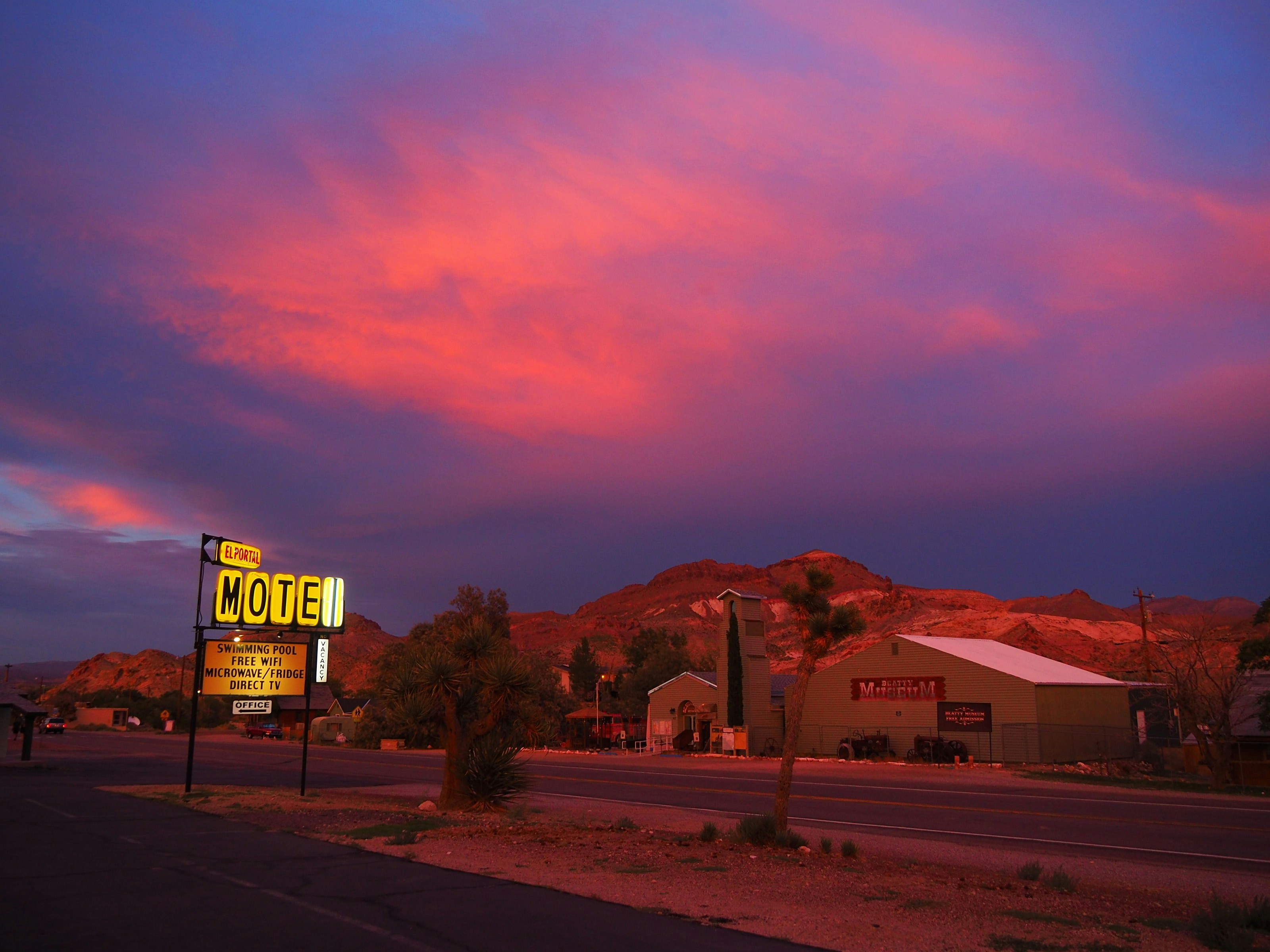 a motel sign sitting on the side of a road