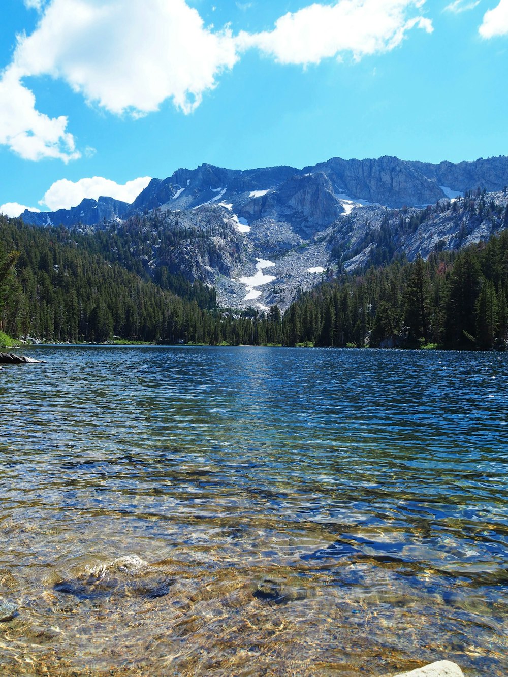 a lake surrounded by mountains with clear water