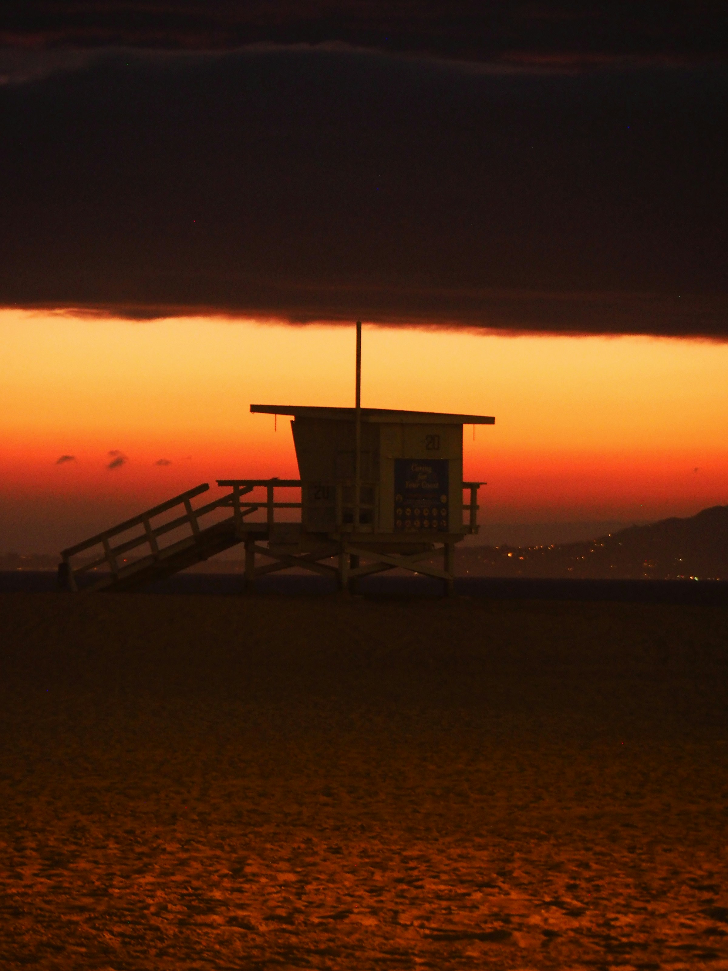 a lifeguard tower sitting on top of a sandy beach