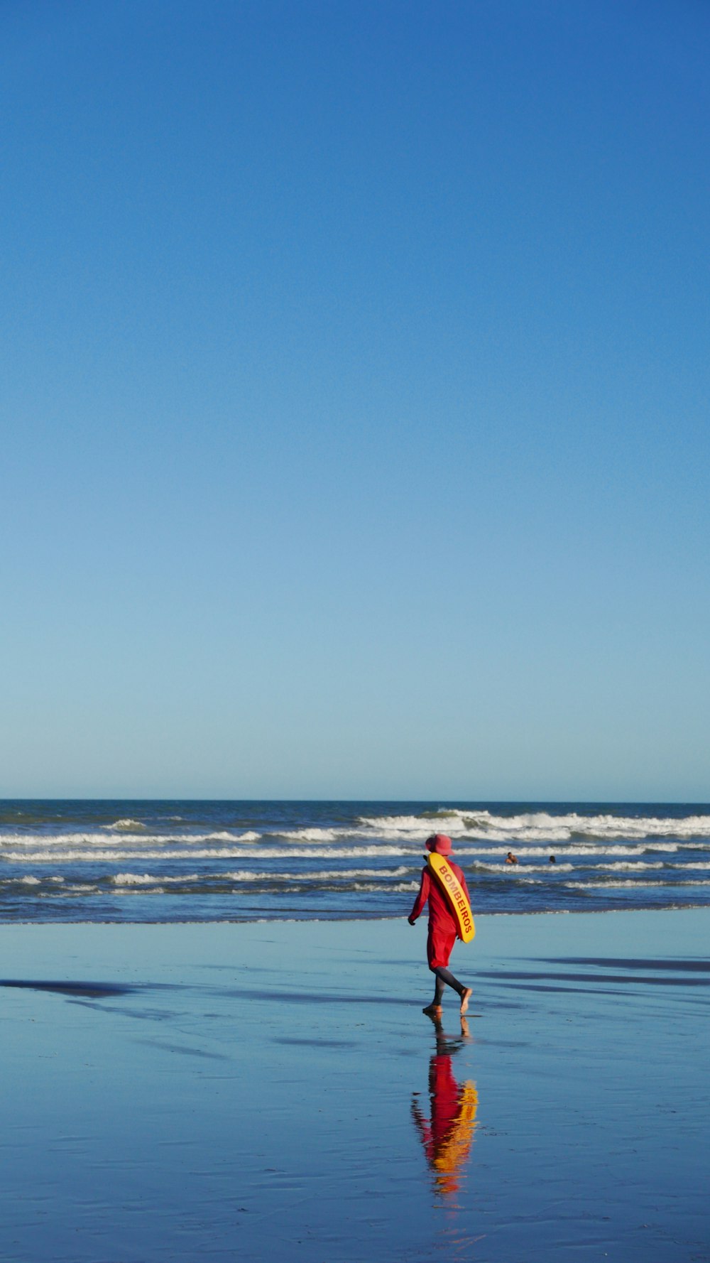 a person walking on a beach with a surfboard