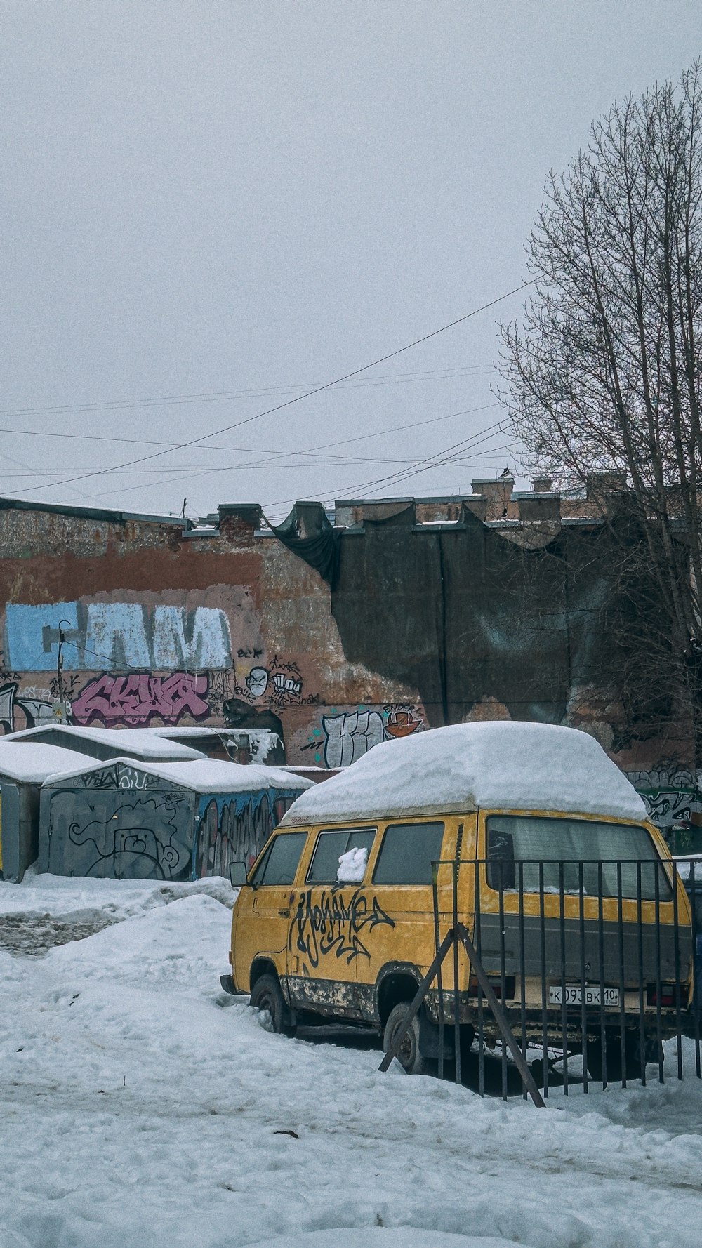 a yellow van parked in the snow near a building