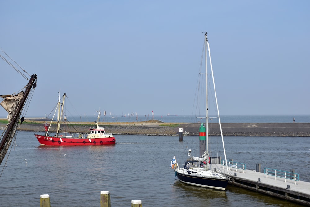 ein rotes Boot im Wasser neben einem Dock