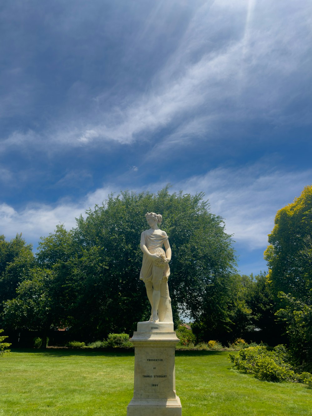 a statue in the middle of a grassy field