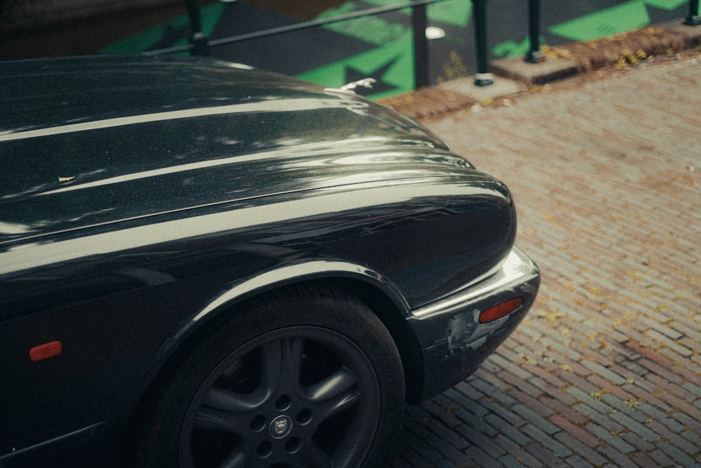 a black sports car parked on a brick road