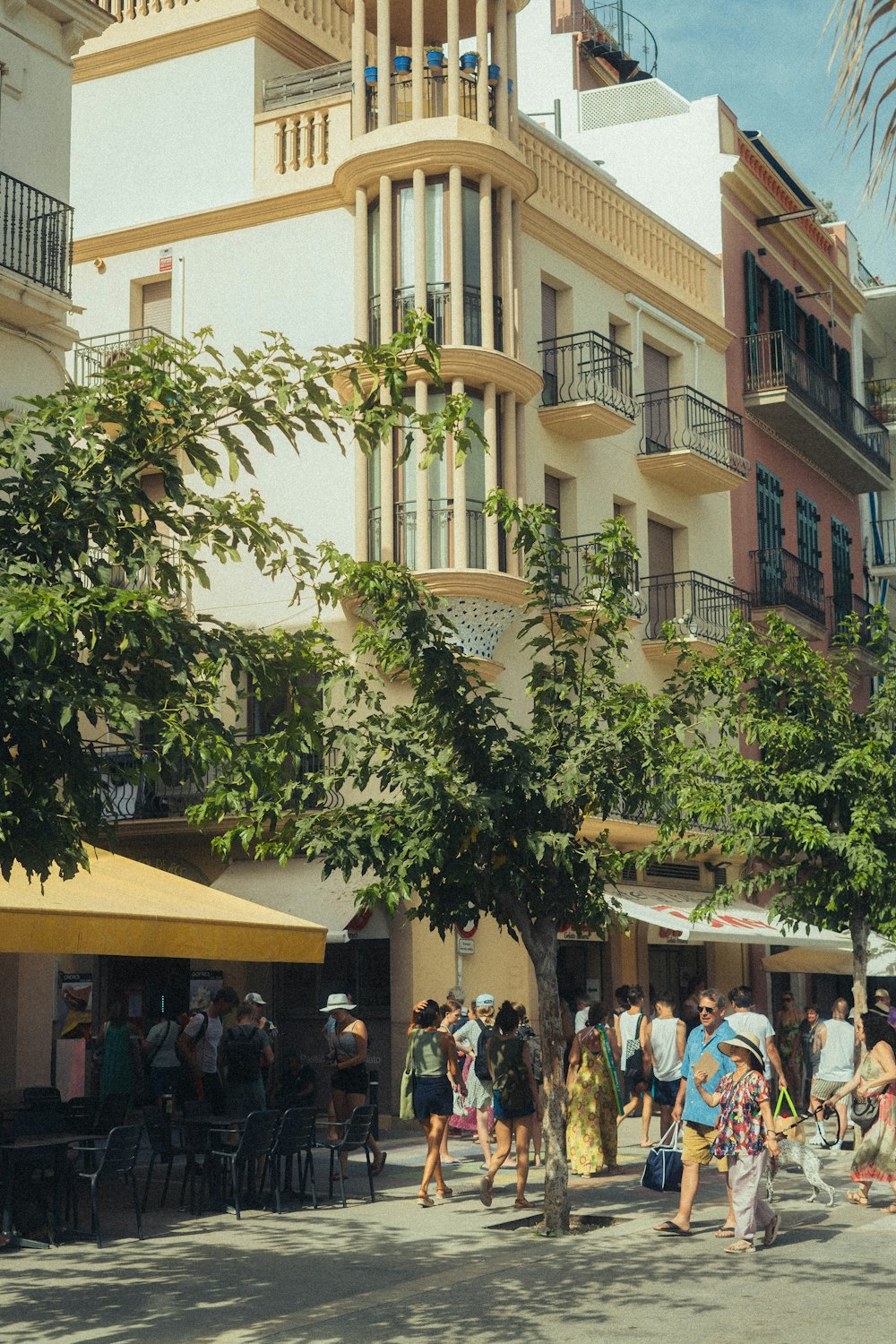 a group of people walking down a street next to a tall building