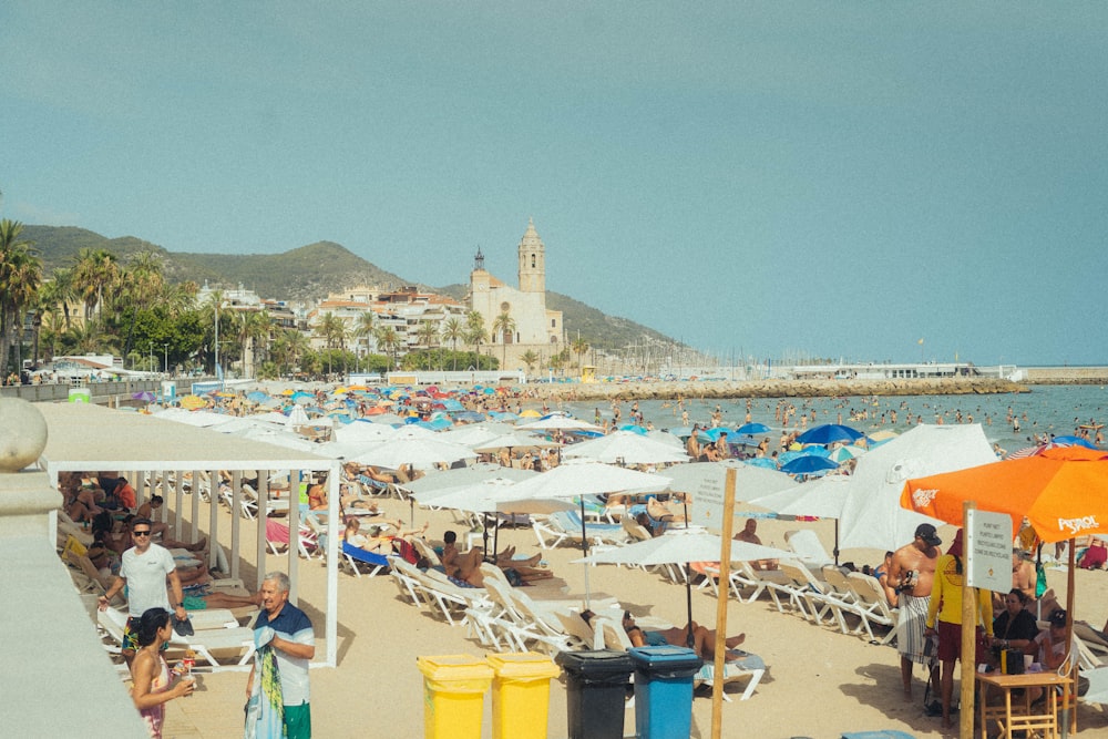 a crowded beach with umbrellas and chairs