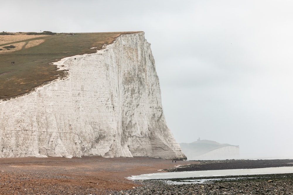 a large white cliff on the side of a beach