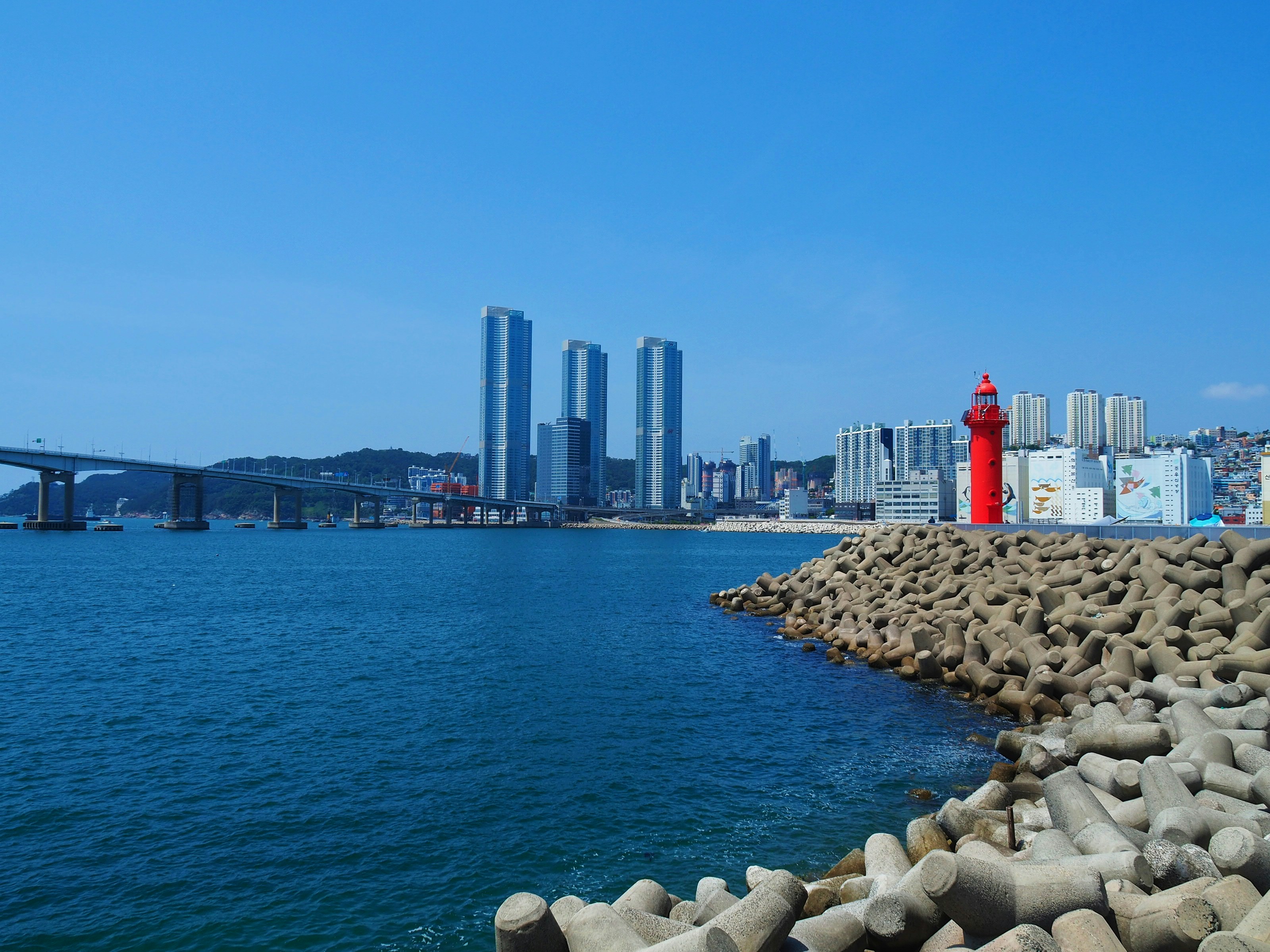 a body of water with a red light house in the middle of it