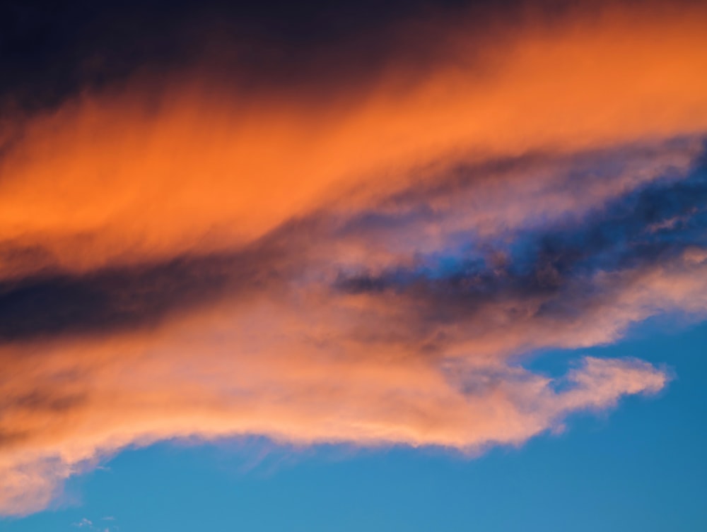 a plane flying in the sky at sunset