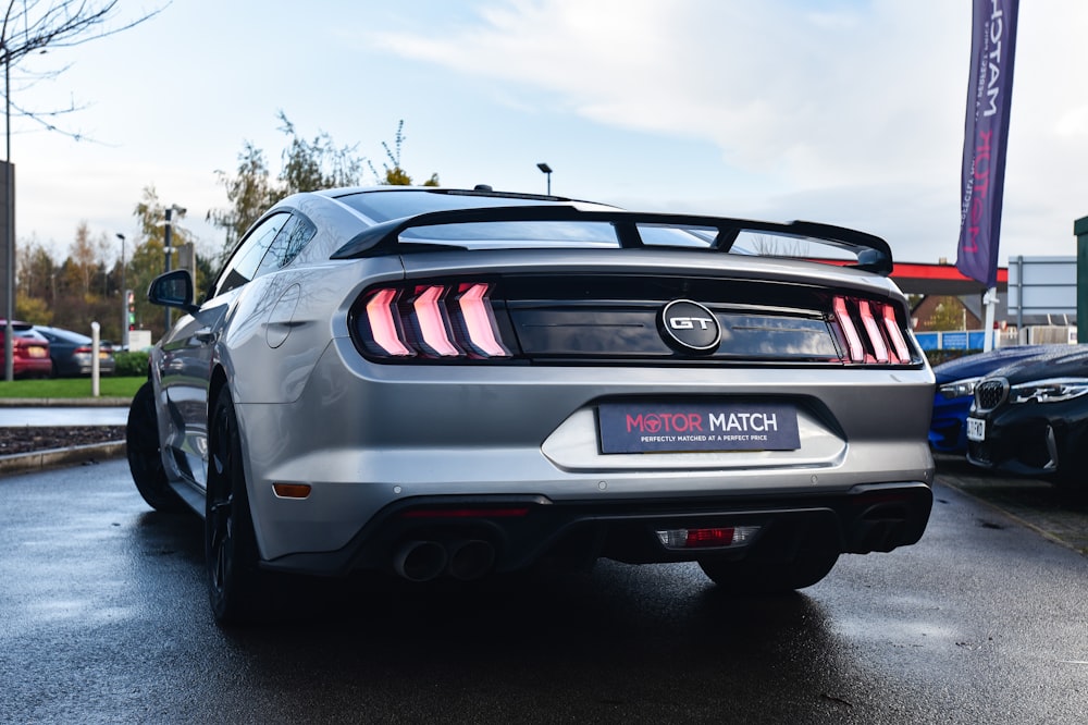 a silver mustang parked in a parking lot