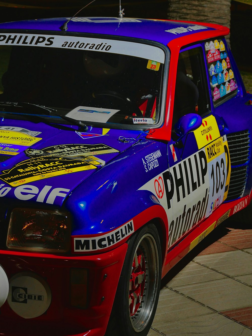 a blue and red race car parked on the side of the road