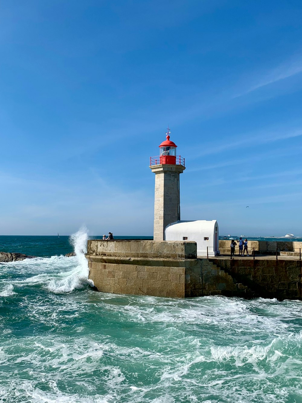 a light house sitting on top of a pier next to the ocean