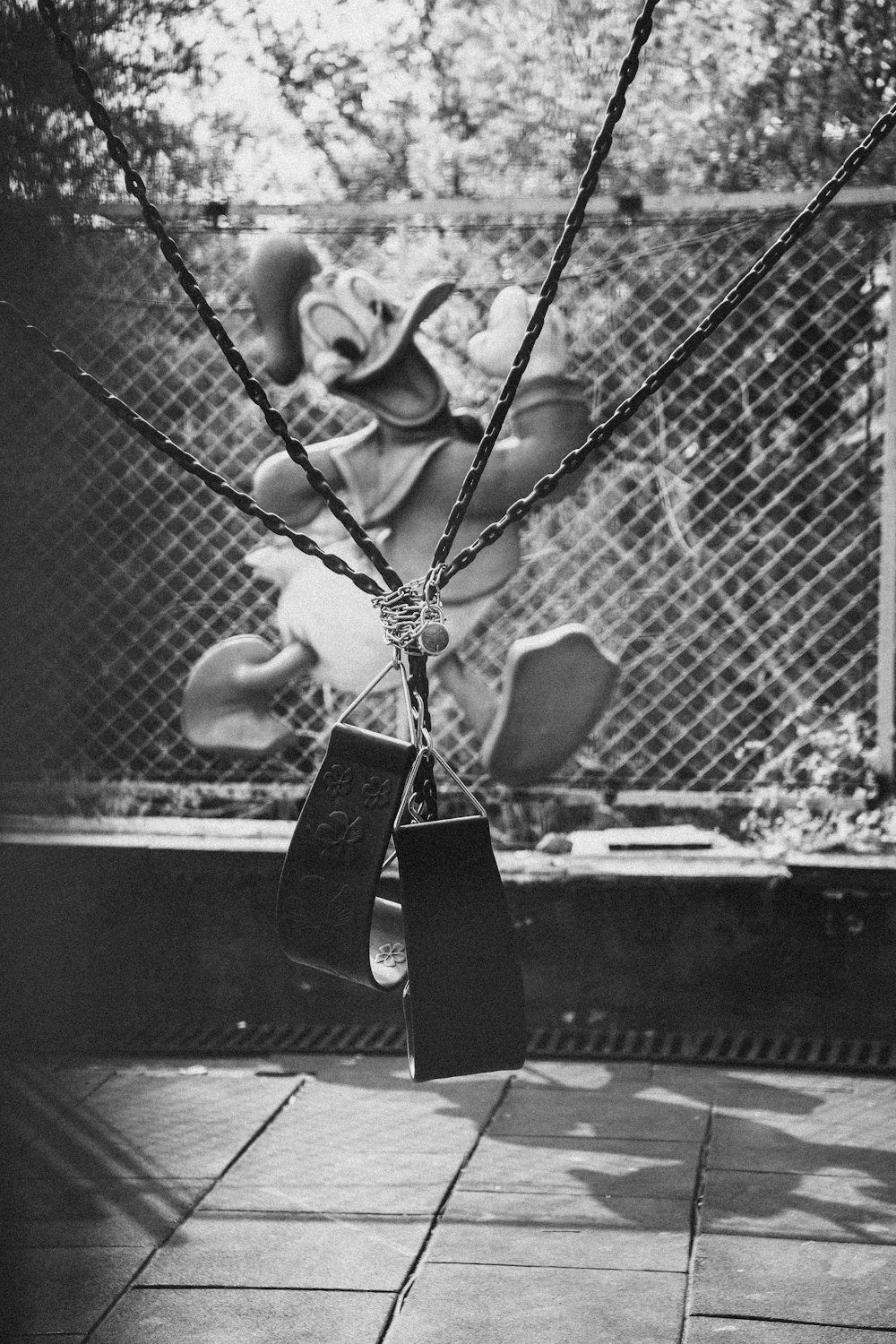 a black and white photo of a swing set