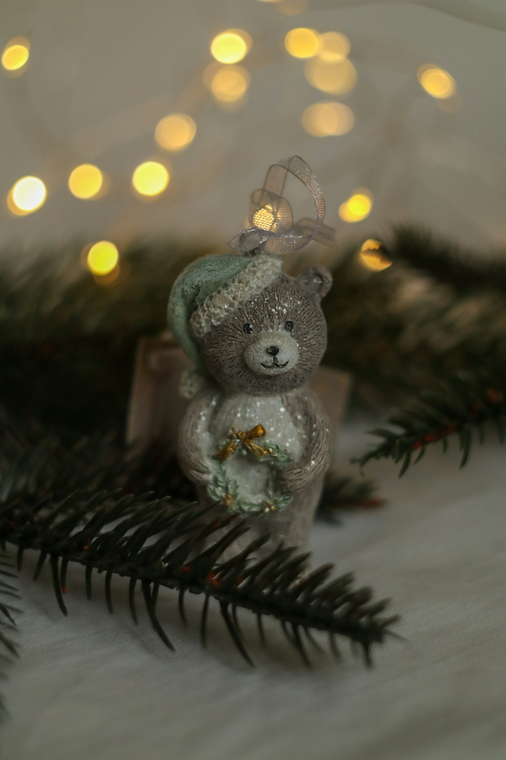 a teddy bear sitting on top of a christmas tree