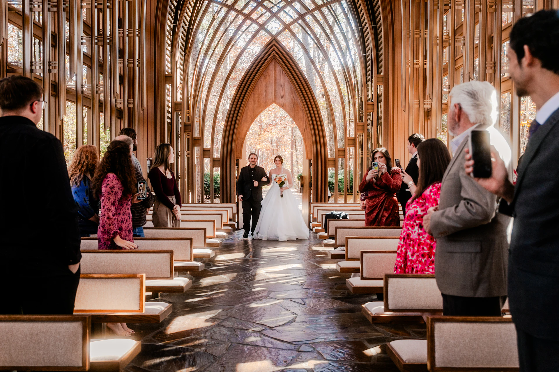 A bride and groom walking together down the aisle of a chapel