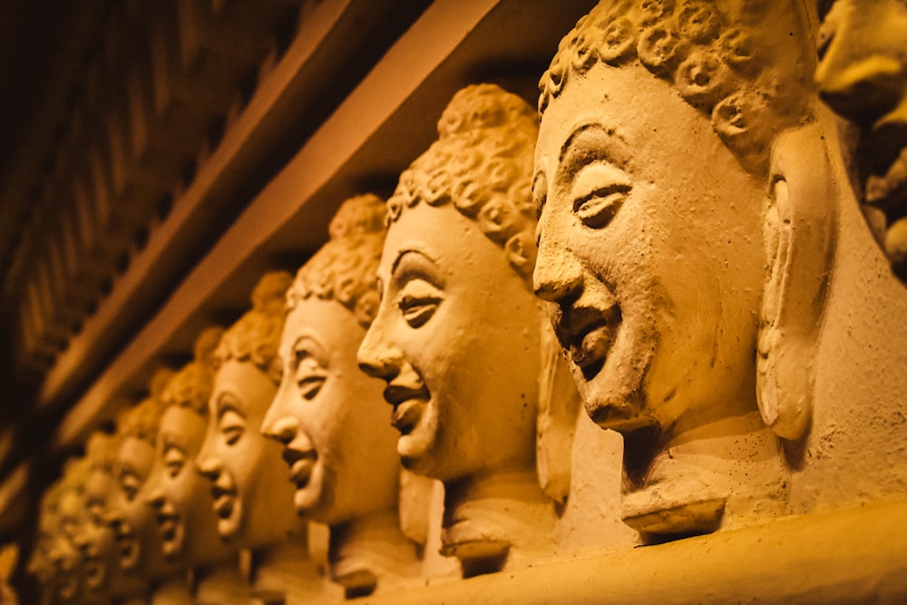 une rangée de têtes de bouddha sur une étagère