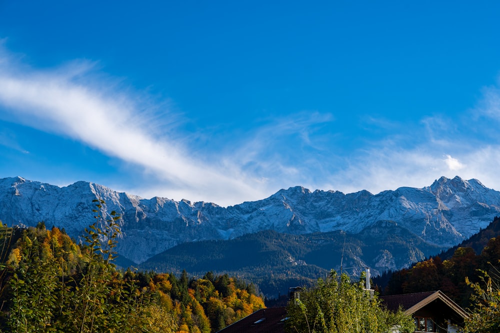 Una vista de una cadena montañosa con una casa en primer plano