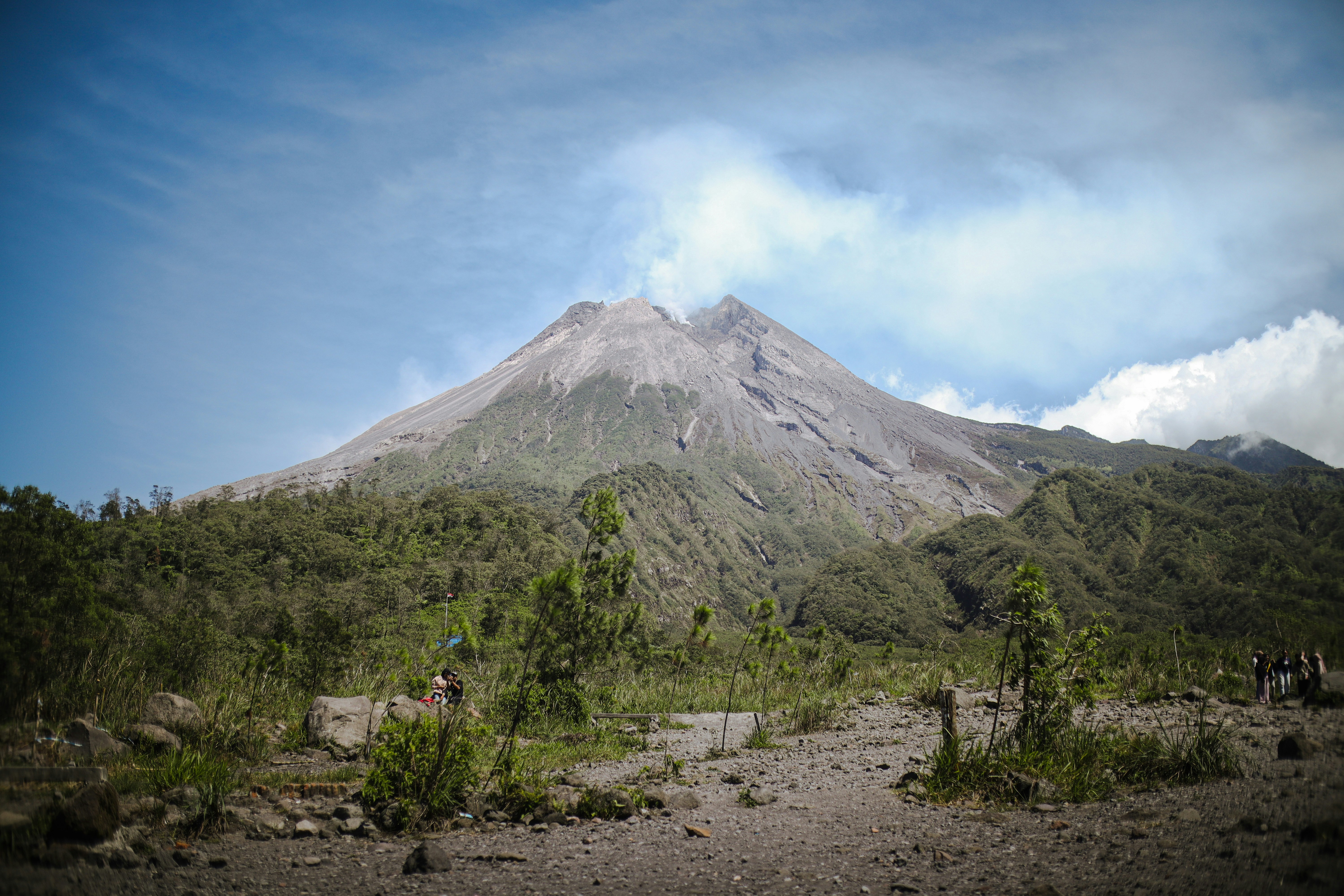 Mount Merapi, an active volcano in central Java, Indonesia, rises 2,930 meters and is known as the "Mountain of Fire." Despite its destructive potential, the surrounding fertile land attracts a dense population. The volcano's history is culturally and geologically significant, making it a subject of ongoing scientific study.