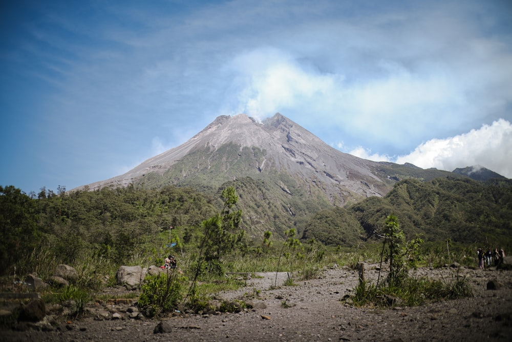 a group of people standing in front of a mountain