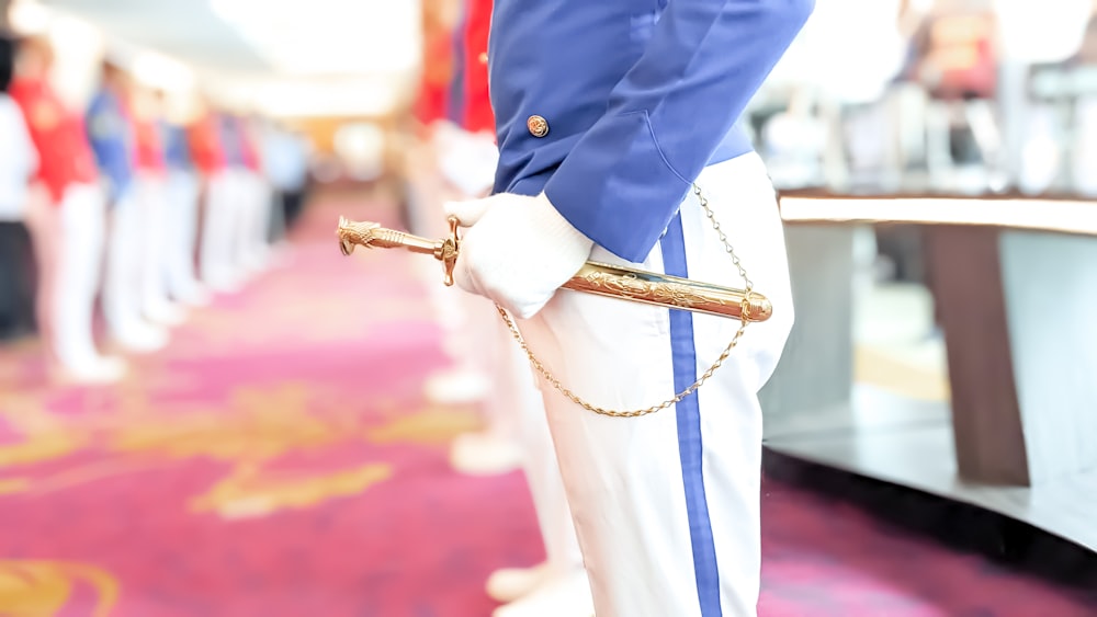 Un primer plano de una persona con uniforme sosteniendo una espada