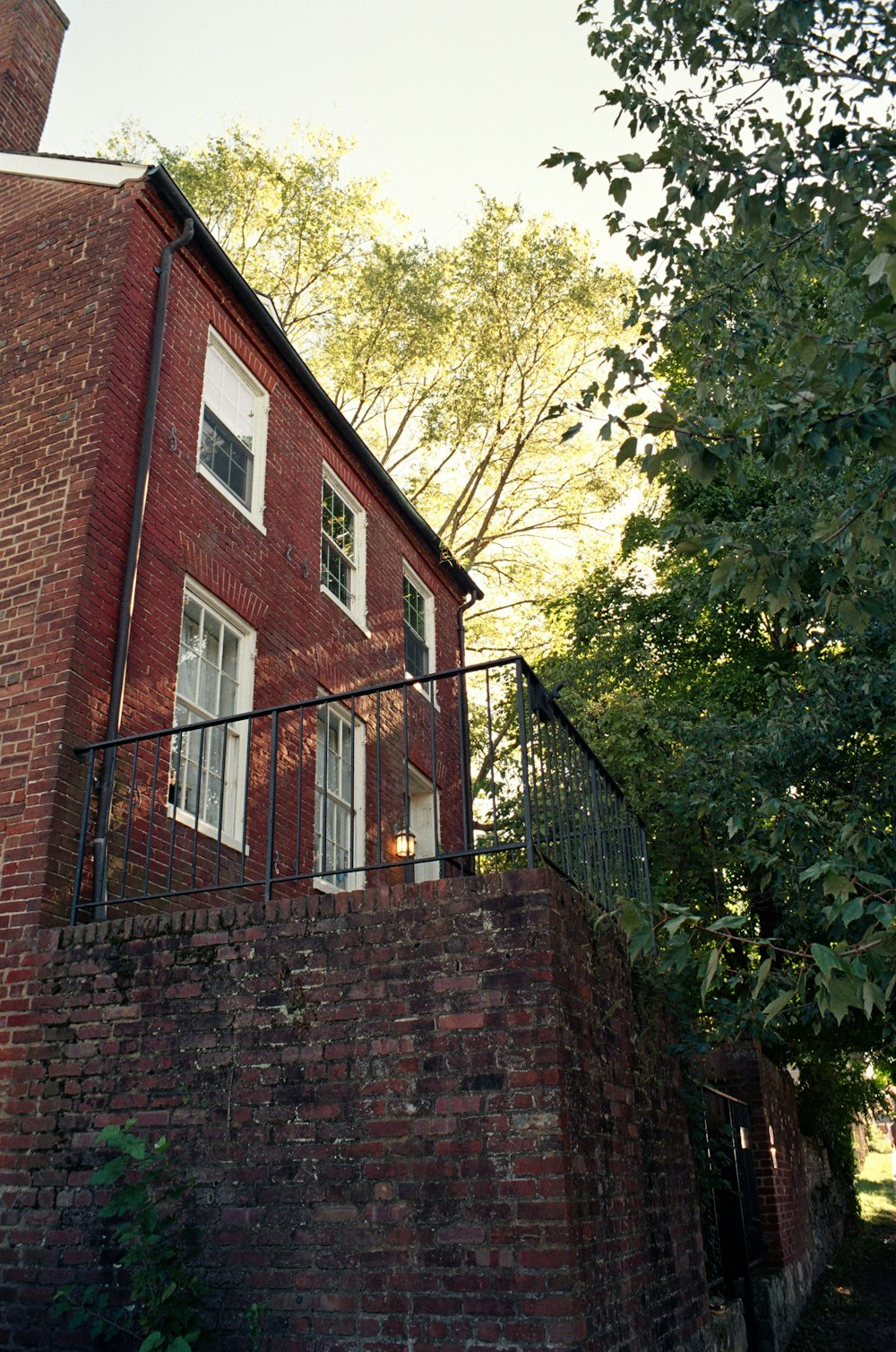 a red brick building with a balcony and a fence