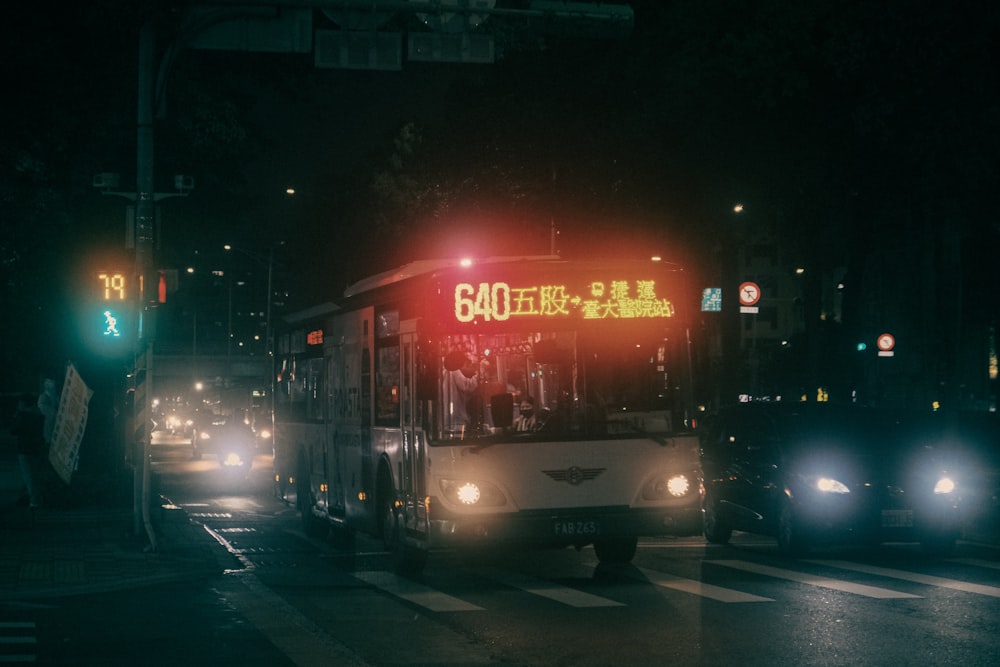 a city bus driving down a street at night