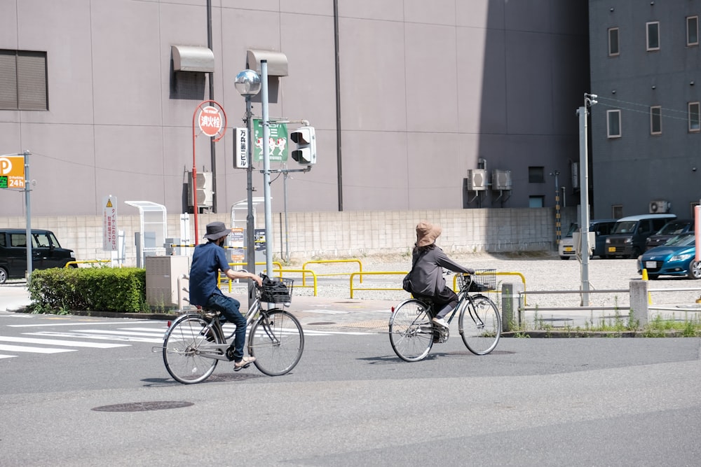 a couple of people riding bikes down a street