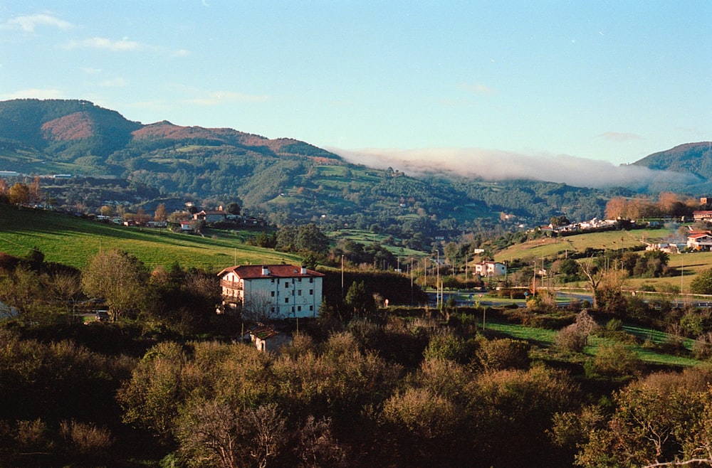 a house in the middle of a lush green valley