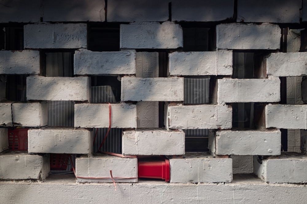 a white brick wall with a red fire hydrant