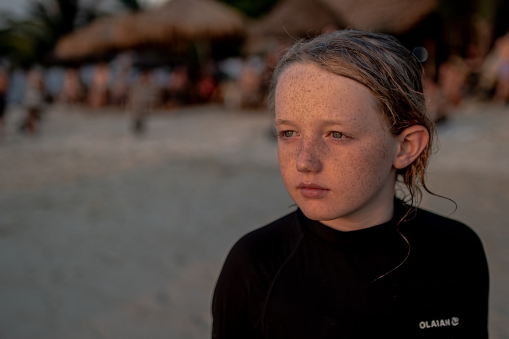 a young girl in a wet suit on a beach