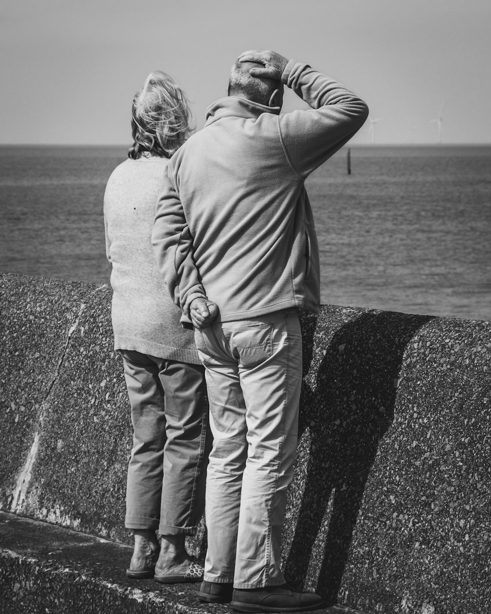 a man and a woman looking out at the ocean