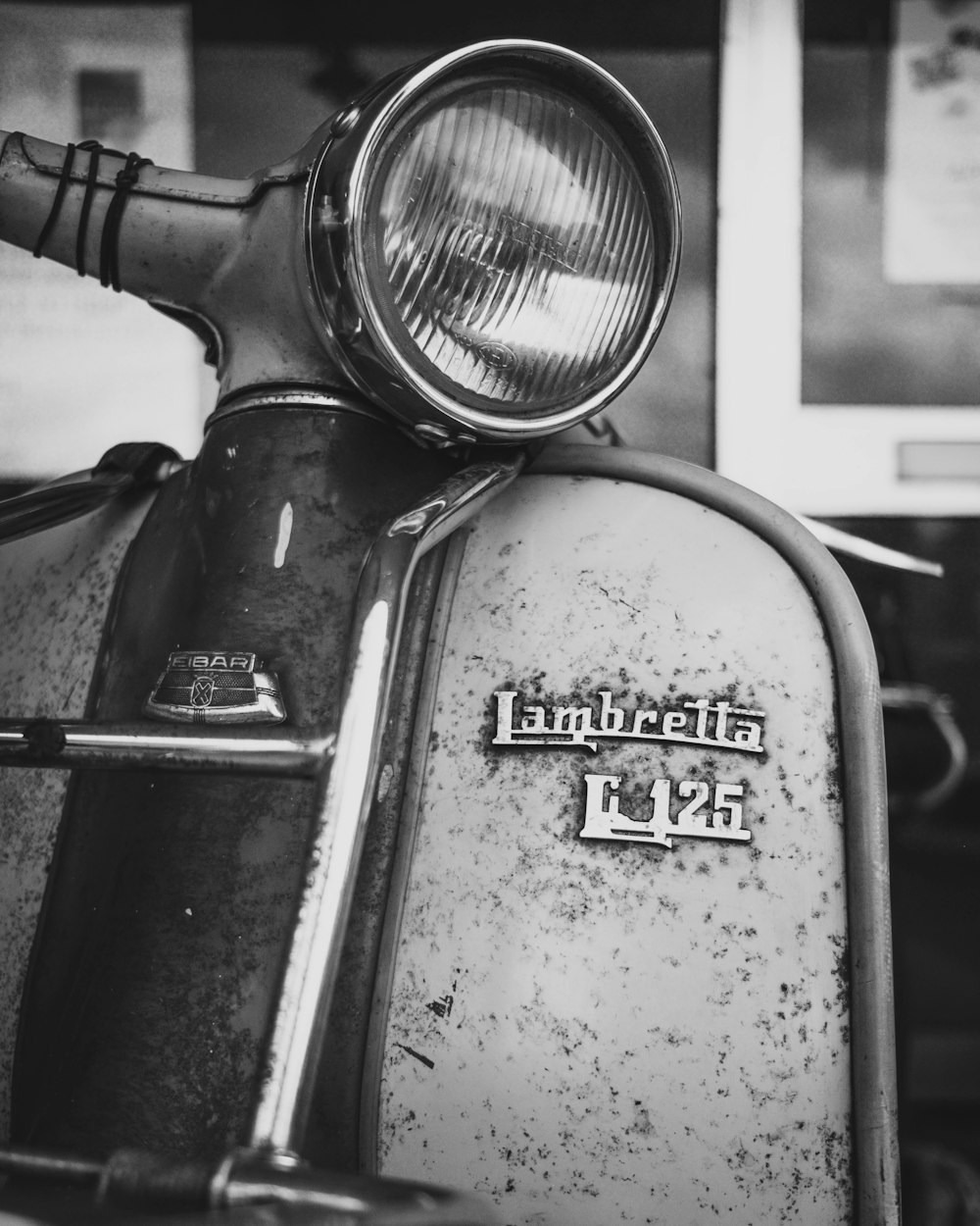 a black and white photo of an old scooter