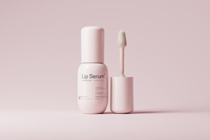 a bottle of lip scrub next to a tube of lip butter