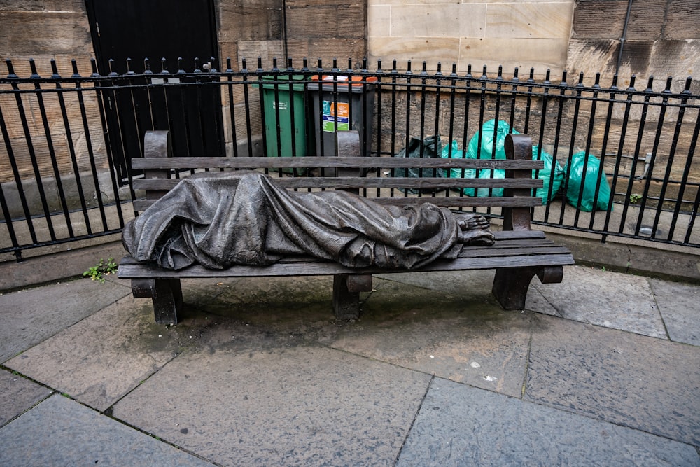 a wooden bench with a blanket on top of it