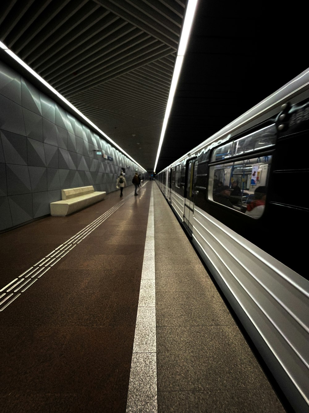 a train traveling through a train station next to a platform