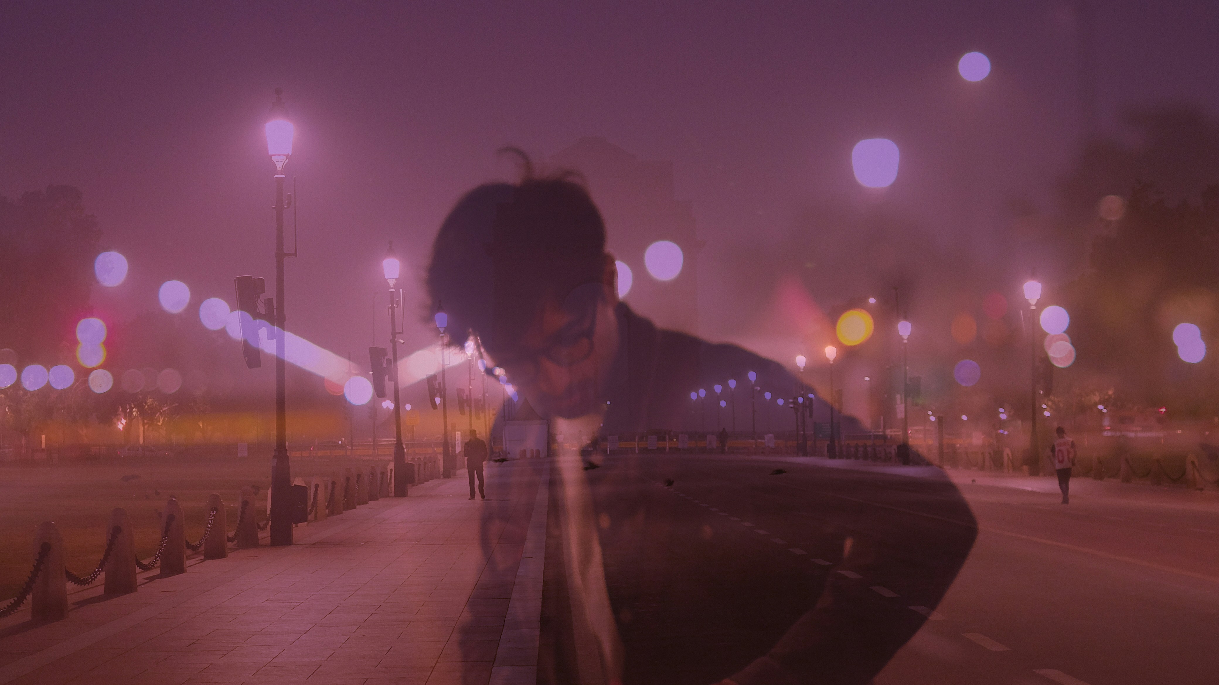 a man standing on a sidewalk at night