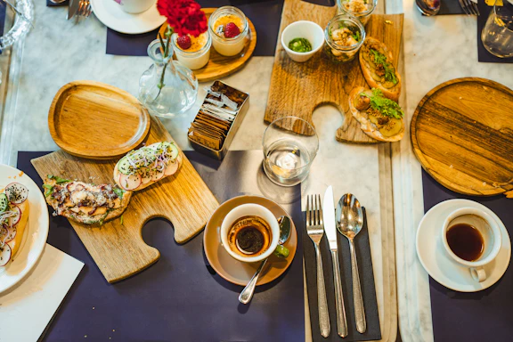 a table topped with plates of food and cups of coffee