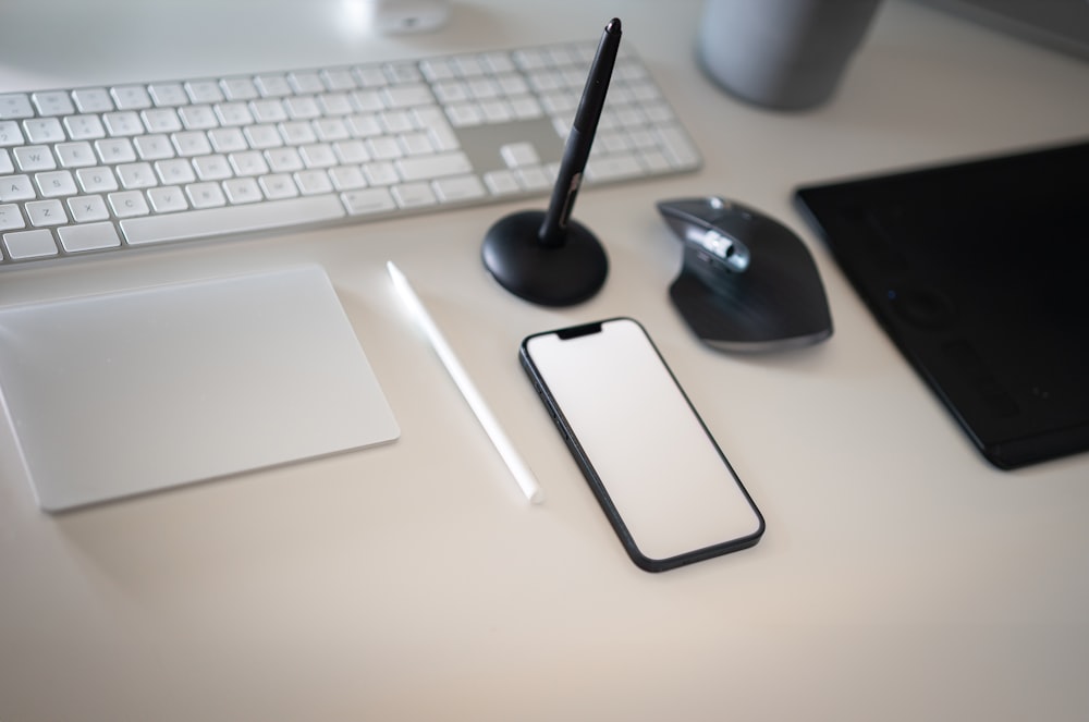 a cell phone sitting on top of a desk next to a keyboard