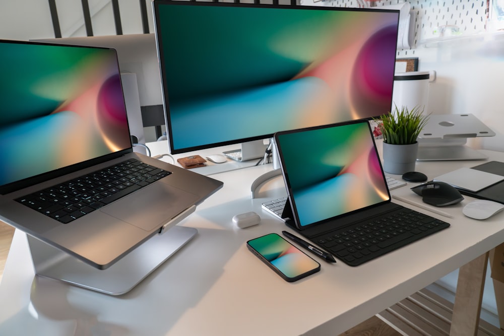 a desk with two laptops and a phone on it