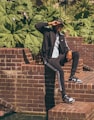 a man sitting on top of a brick wall