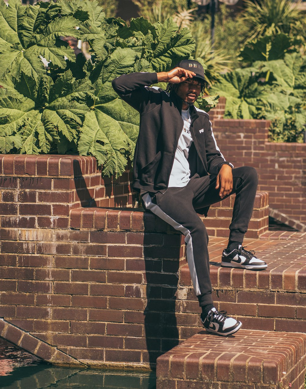 a man sitting on top of a brick wall