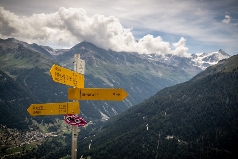 a yellow street sign sitting on the side of a mountain