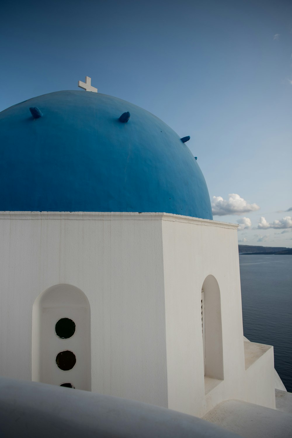 a white and blue building with a cross on it