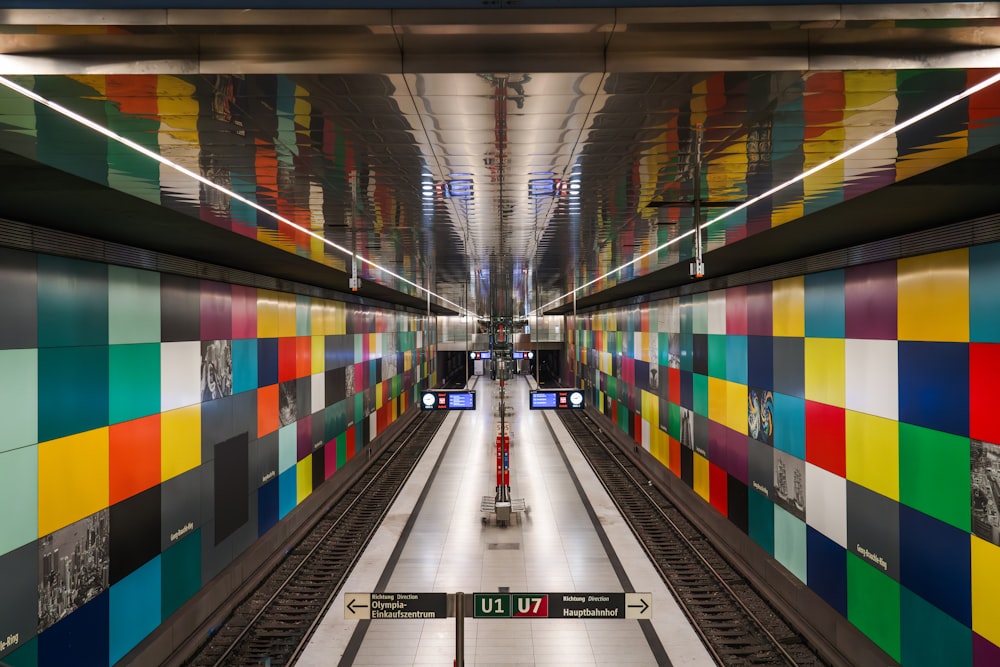 a subway station with colorful tiles on the walls