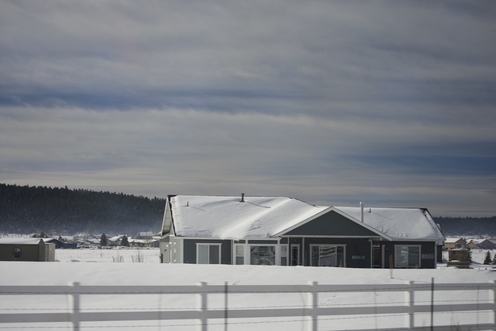 a house in the middle of a snowy field