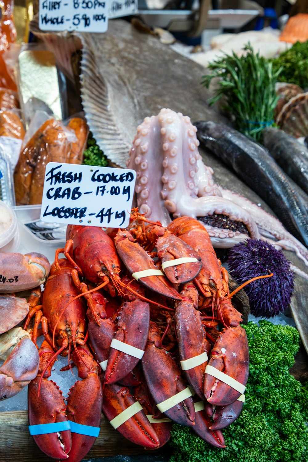 fresh lobsters and other seafood on display at a market