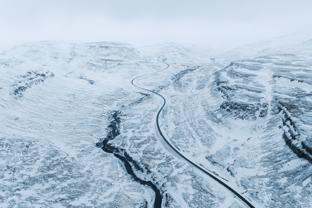 a winding road in the middle of a snow covered mountain