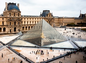 a large glass pyramid in front of a building